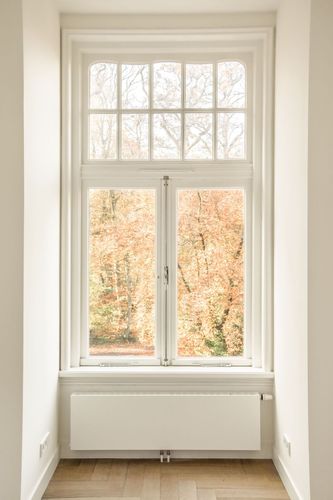 Heruntergelassener Aluminium-Rollladen an einem weißen Kunststofffenster